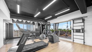 Ein modernes Fitnessstudio mit Laufband, Crosstrainer und verschiedenen Trainingsgeräten.