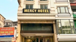 Un edificio de varios pisos con un cartel que dice 'Mercy Hotel'.