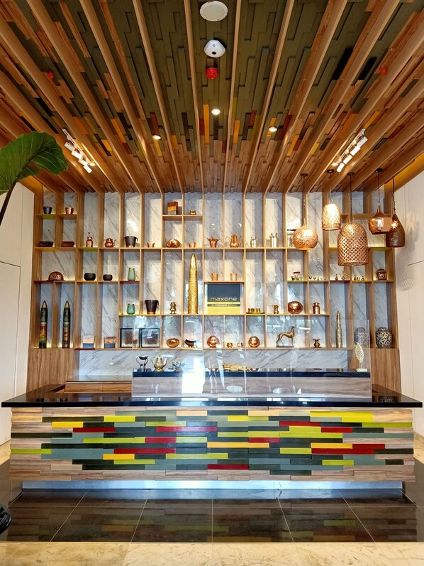 A modern interior with a wooden ceiling, marble walls, and a colorful, multicolored display at the front. - MaxOne Loji Kridanggo at Boyolali (Boyolali)