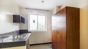 A kitchen with a sink, cabinets, and a window. - Vaccinated Staff - OYO 850 Clr Mn Inn (Quezon City)