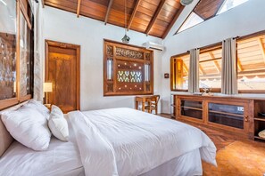 A bedroom with a wooden ceiling, a bed with white bedding, a wooden desk, and a window with curtains. - AV Villa Canggu Hearts (Canggu)