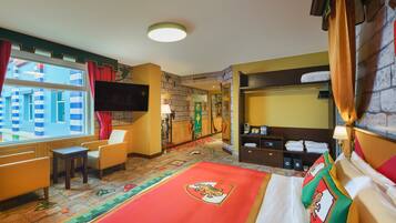 Una habitación de hotel con una cama grande, un escritorio, una silla, un televisor, un armario y una ventana con cortinas.