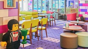 Un interior vibrante con asientos coloridos, una figura LEGO y un letrero de neón que dice "Skyline Lounge".