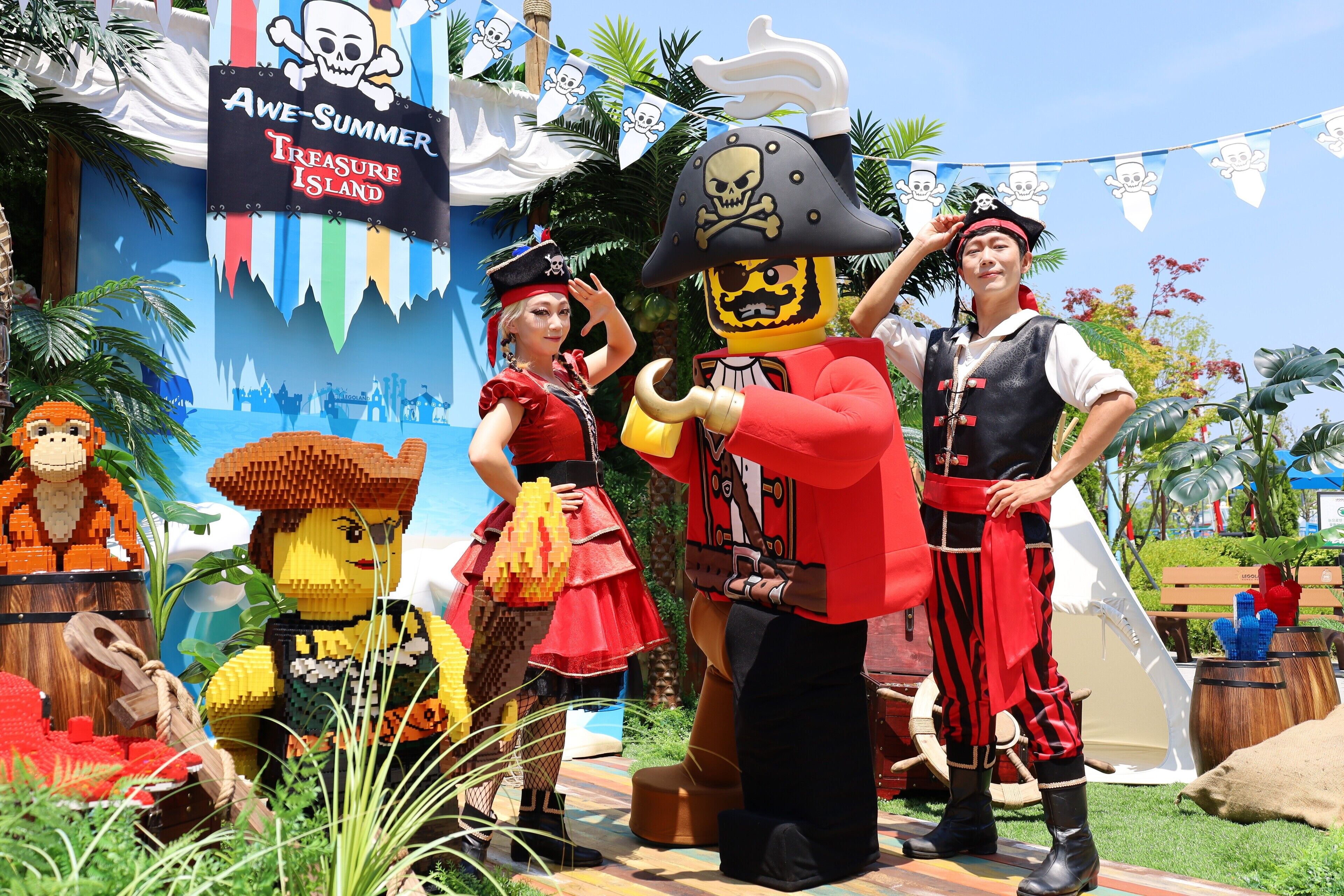 Una exhibición temática de piratas LEGO con personajes y un fondo que dice 'Isla del Tesoro de Verano Asombrosa'.