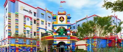 A LEGO-themed hotel with colorful architecture, a dragon statue, and a flag.