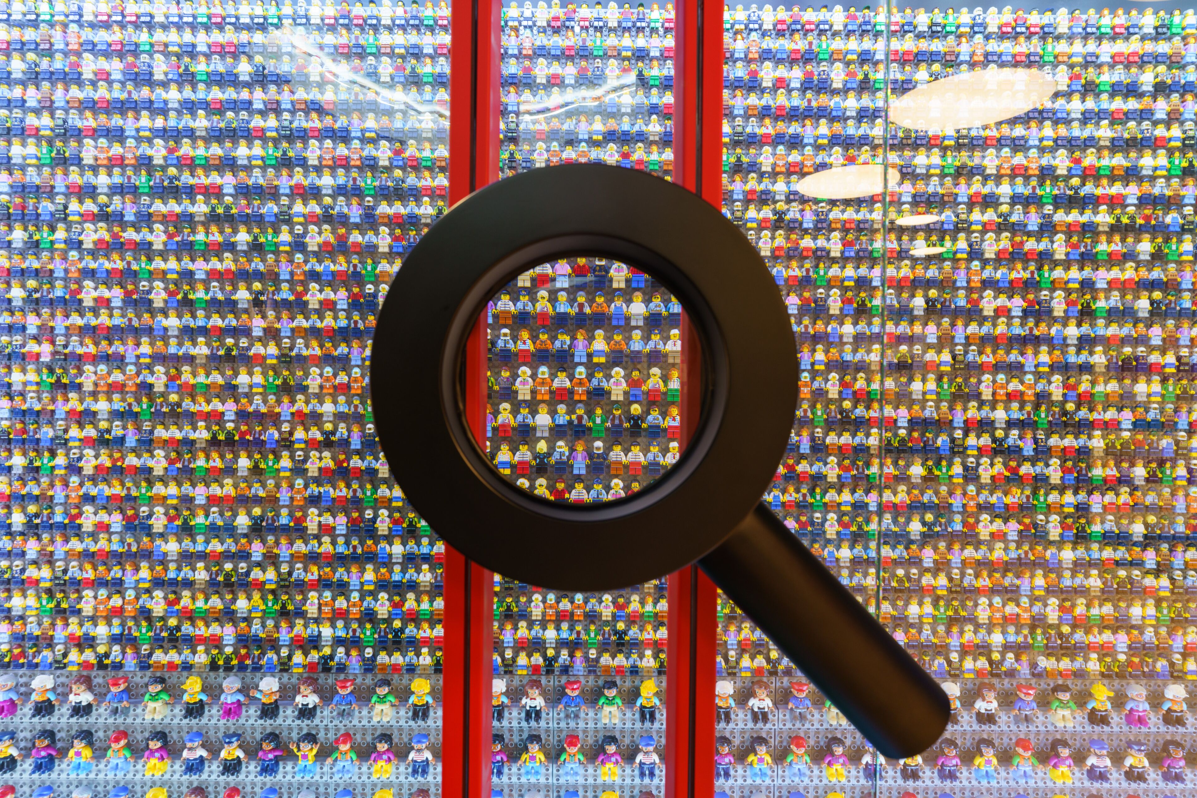 Una lupa sobre una pared de minifiguras LEGO.