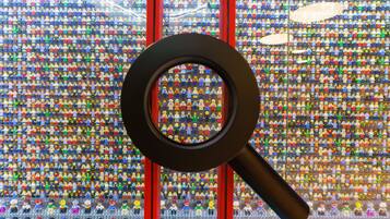 Una lupa sobre una pared de minifiguras LEGO.