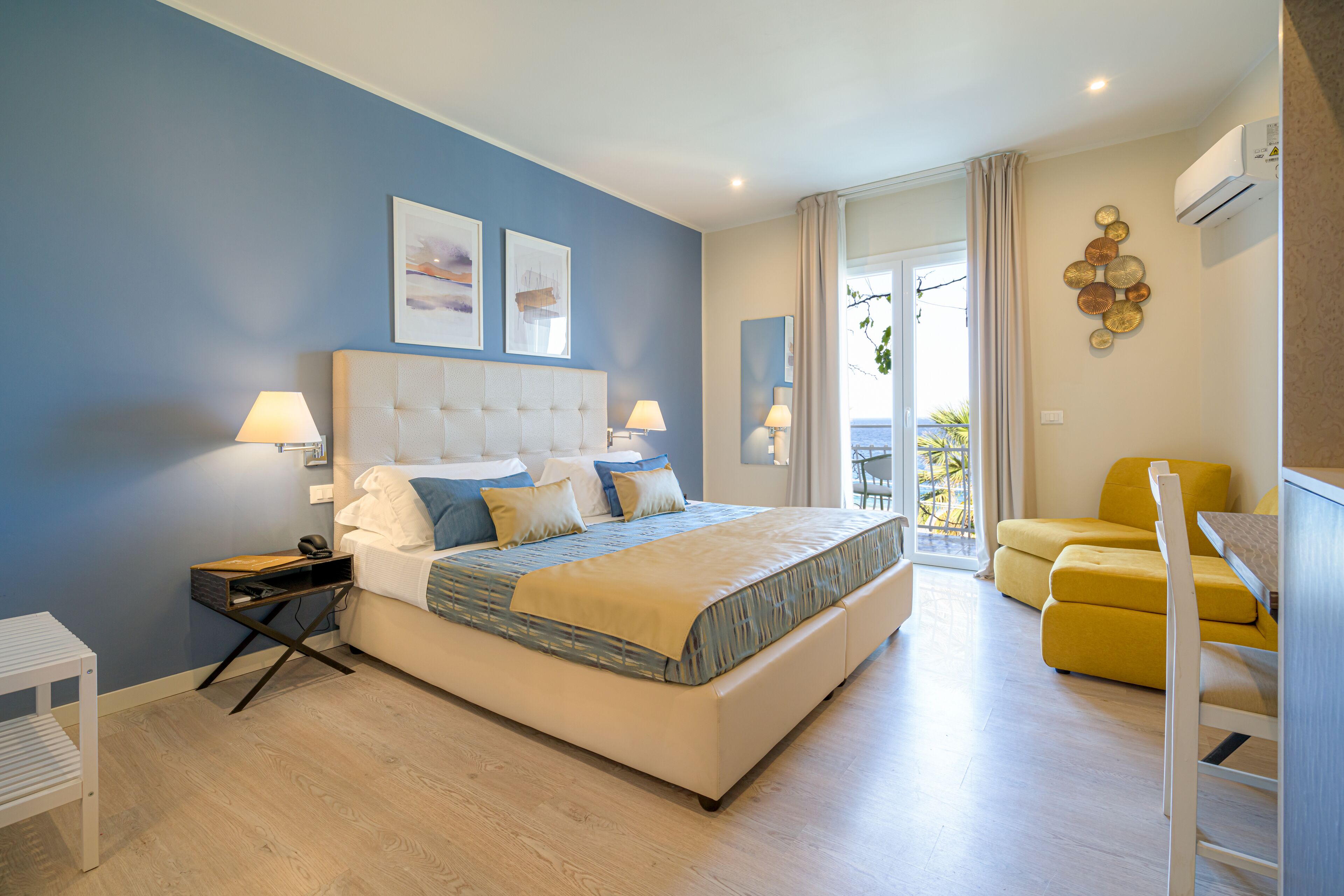 A modern bedroom with a large bed, bedside tables, a chair, and a view of the outdoors.