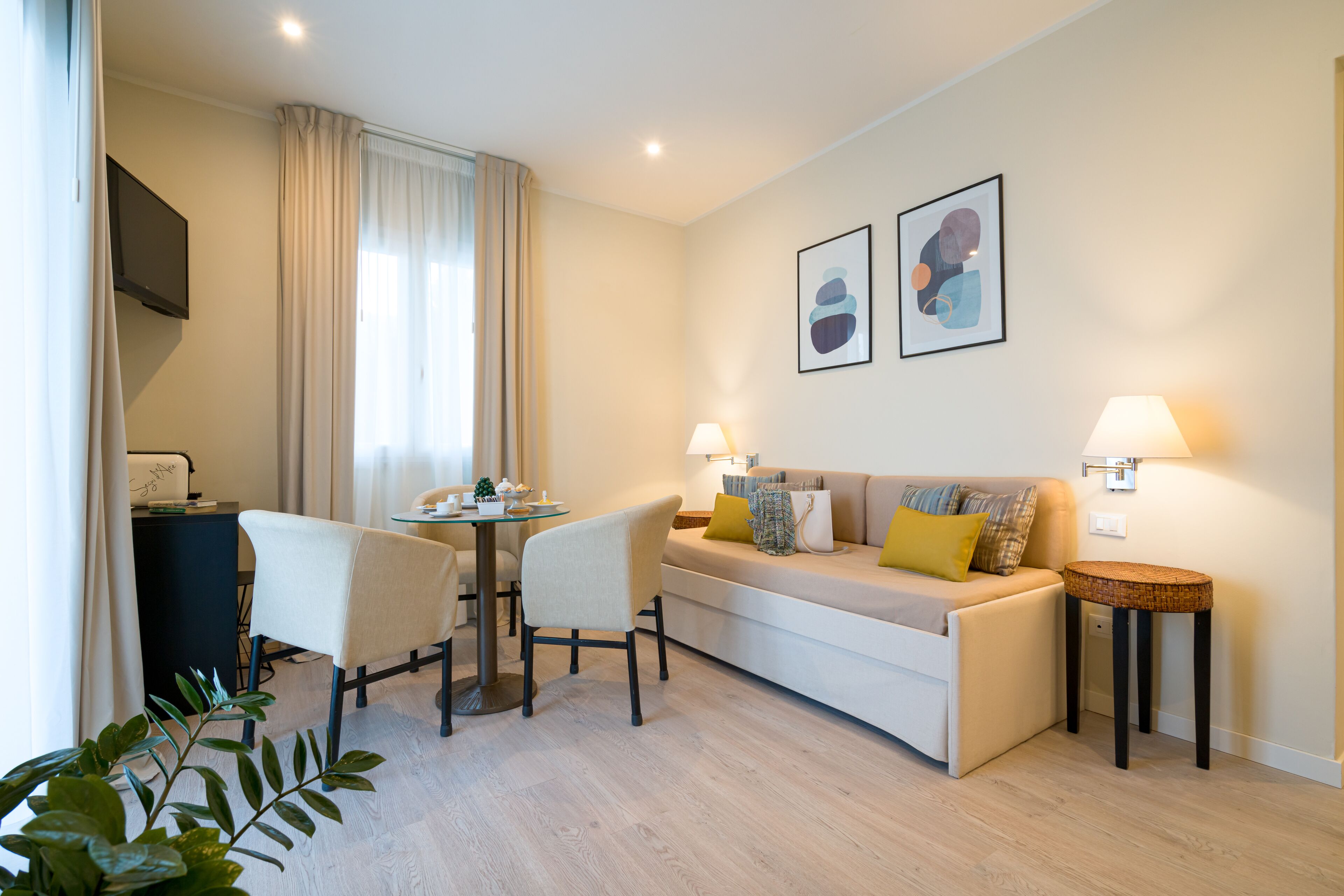 Un salon moderne comprenant un canapé, deux fauteuils, une petite table et une lampe.