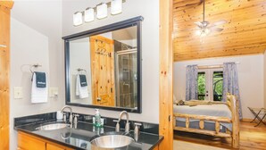 Une salle de bain avec un double lavabo, un grand miroir et des meubles en bois.