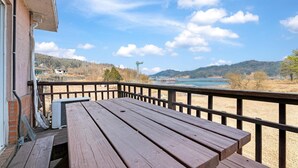 Eine Holzterrasse mit Blick auf einen See und Berge.