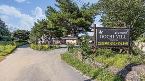 Schild für 'DOCHI VILL PENSION' mit einer Kontaktnummer.