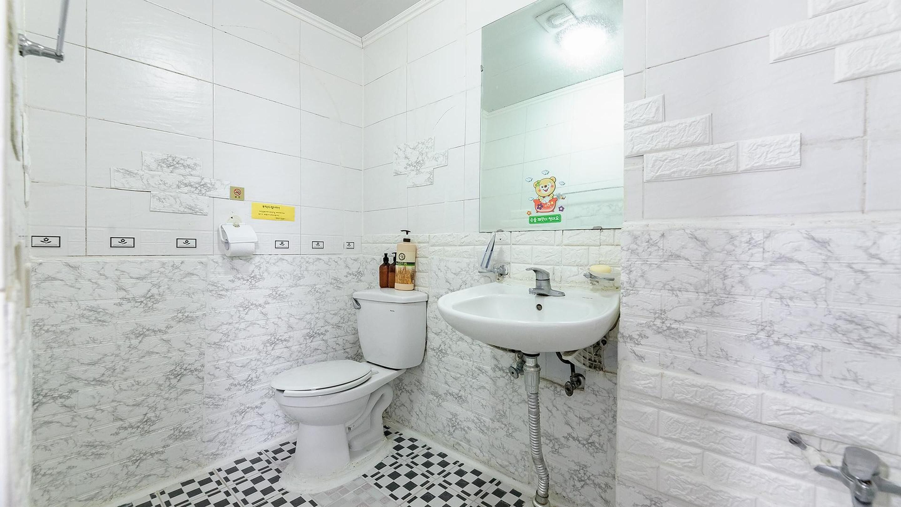 A small bathroom with a toilet, sink, and mirror.