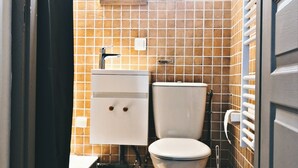 Une petite salle de bain comprenant des toilettes, un lavabo et un miroir.