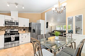 Enjoy meals at the glass-top dining table surrounded by comfortable chairs.