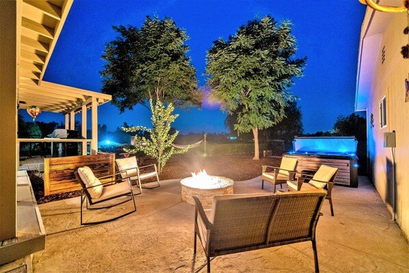 Relax and socialize in this inviting outdoor space, featuring a fire pit, comfortable seating, and a barbecue grill.