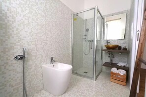 A bathroom with a glass shower enclosure, a white sink, and a mirror above the sink. - Baby Hotel (Turin)
