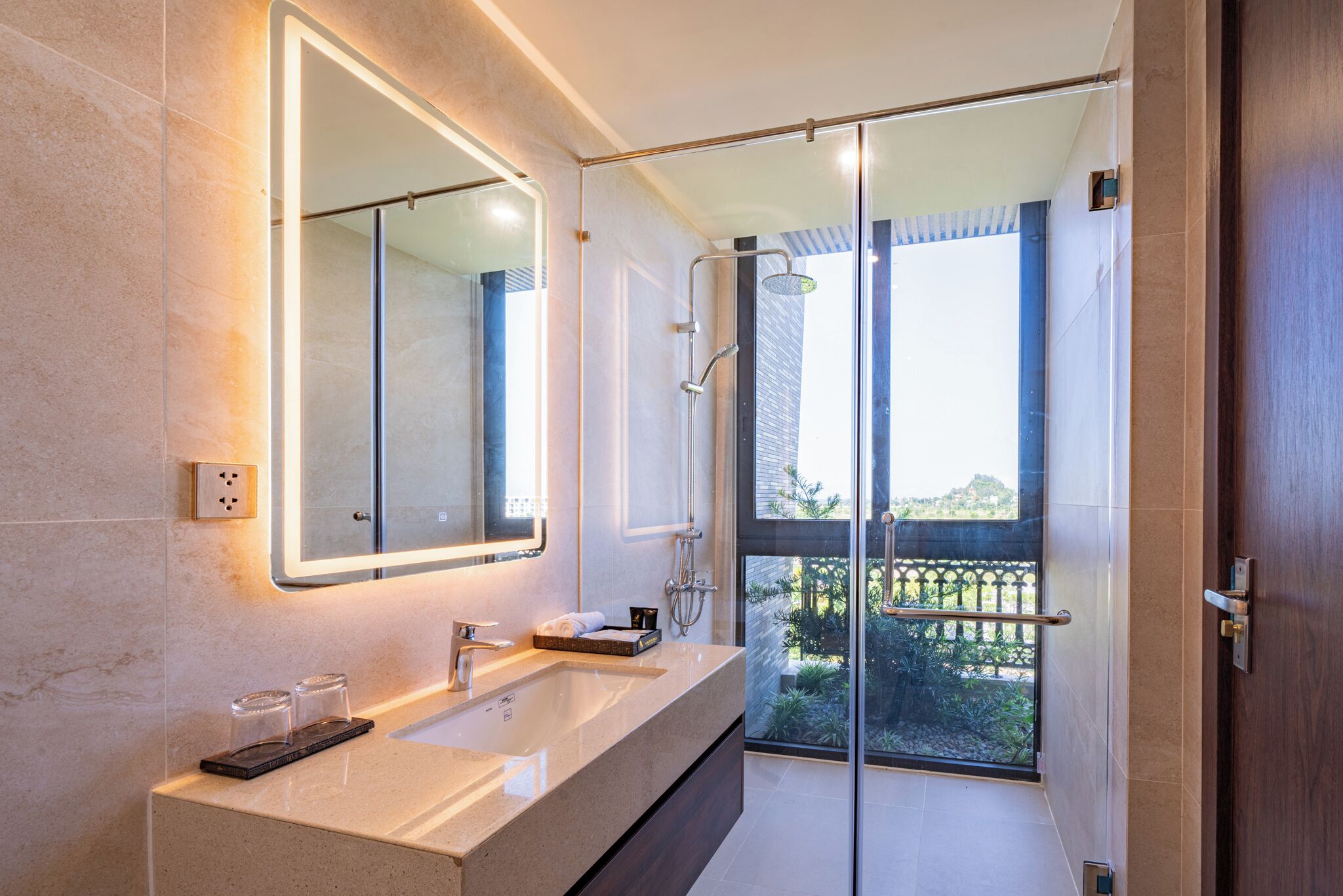 Un bagno moderno con uno specchio grande, due lavabi e una cabina doccia in vetro.