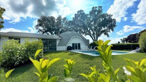 A modern house with a swimming pool, surrounded by well-maintained lawn and trees. - Sumner Lake House 2 Bedrooms (Clermont)