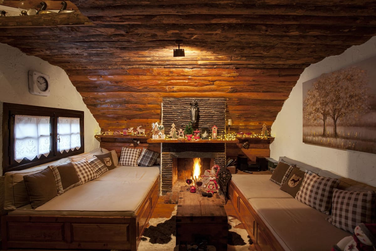 Ein gemütliches Blockhaus-Interieur mit Kamin, Holzmöbeln und rustikalem Dekor.