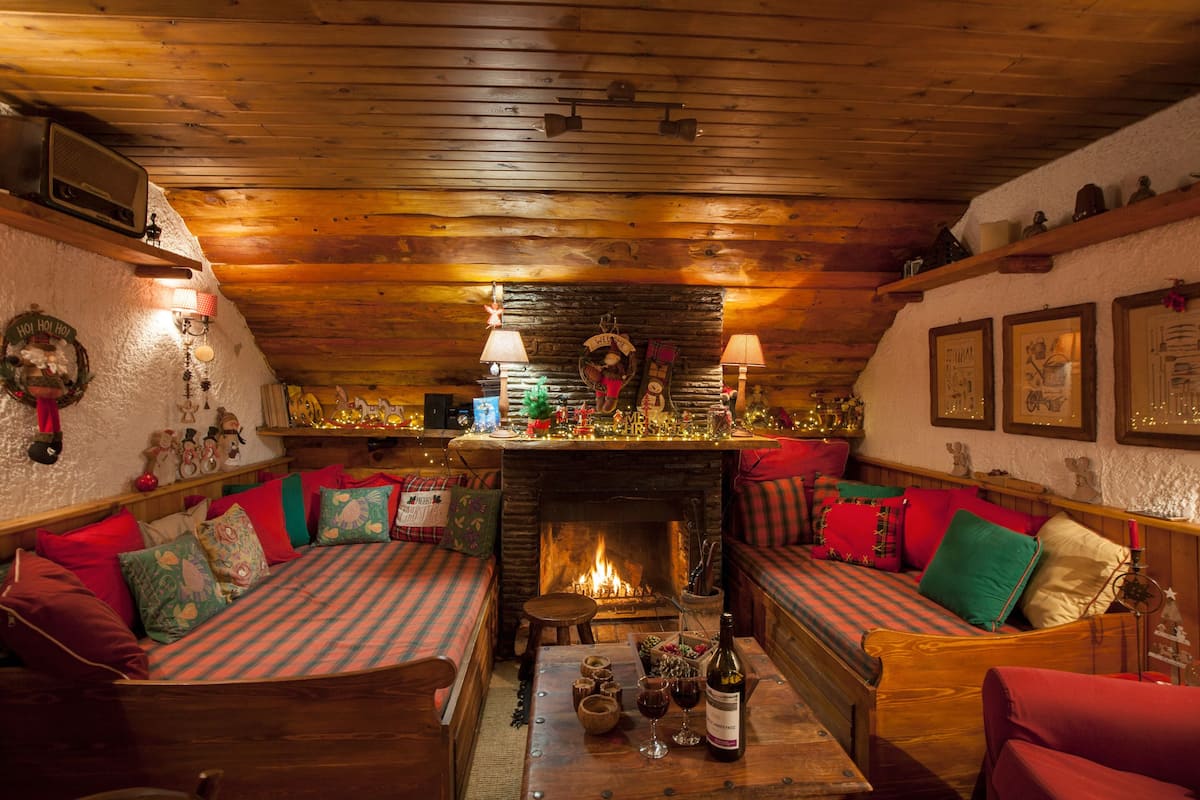 Ein gemütliches Zimmer mit Kamin, Holzmöbeln und festlicher Dekoration.