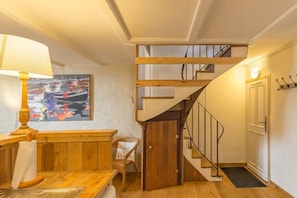 A wooden staircase with a metal railing leading to a second floor. - The harbour house (Granville)