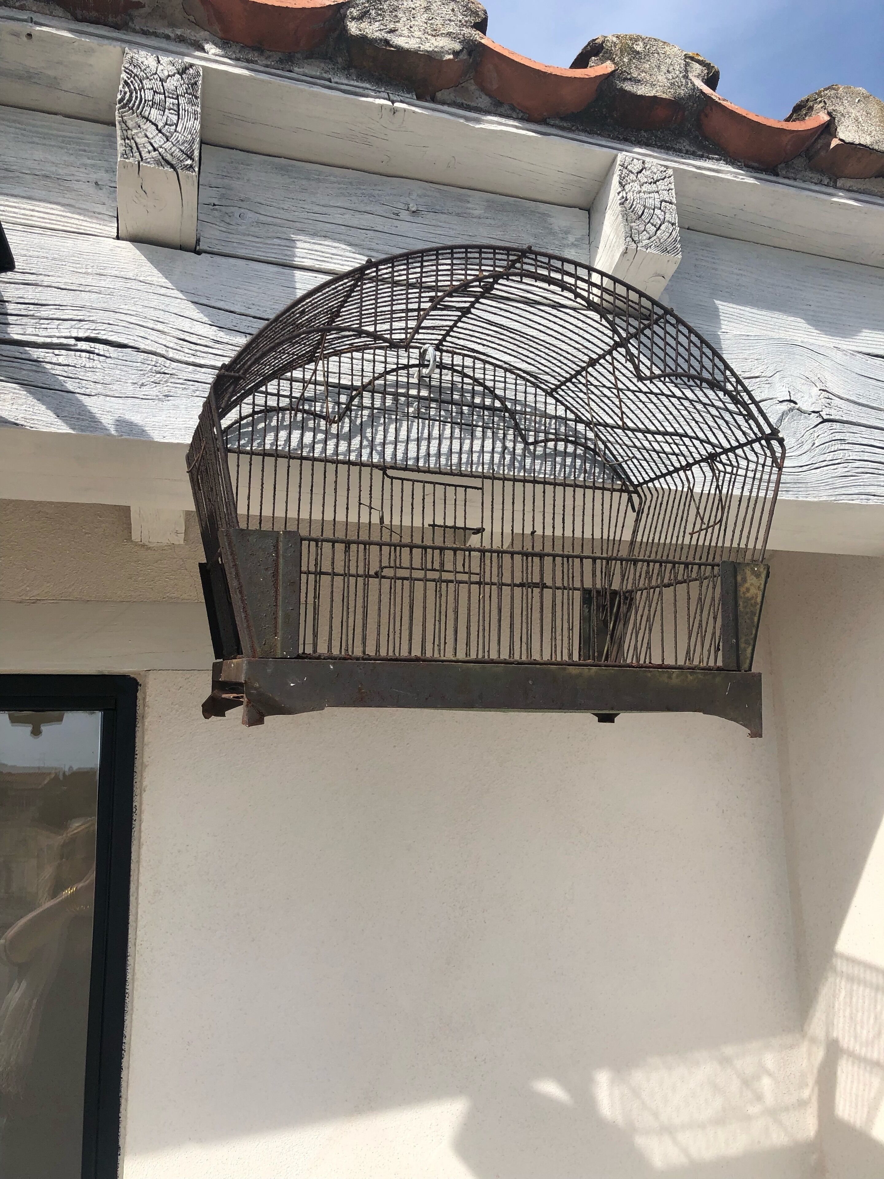 A metal balcony railing attached to a building's exterior wall.