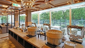 A buffet area with a large central pot, a steam cooker, and a buffet counter with plates and utensils. - Chisun Hotel Yokohama Isezakicho (Yokohama)