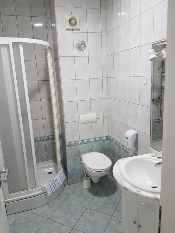 A bathroom with a shower, toilet, and sink. - Guesthouse Aurora (Trpanj)