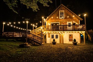A wooden cabin with a balcony, a staircase, and string lights. - Dream Stratton Forest Cabin w/Hot Tub & Fast WiFi (Stratton)