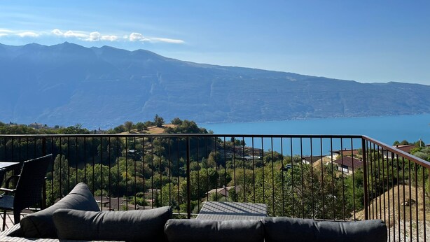 A balcony with a view of mountains and a lake. - Cozy vacation bungalow with breathtaking lake view (Tignale)