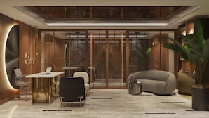 Une salle de bien-être moderne, aménagée comme un spa, avec une paroi en verre, une table de massage, un canapé et une table basse.