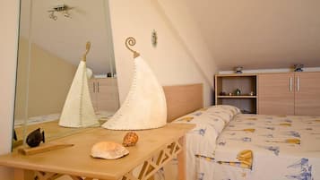 Ein Schlafzimmer mit einem Bett, einem Nachttisch aus Holz, einem Spiegel und einem Kleiderschrank.
