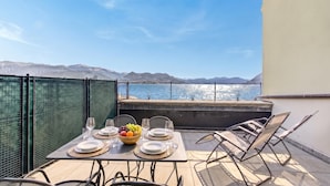 A table set for dining with a view of the sea and mountains. - Rooftop - AC, Lake View With Terrace (Stresa)