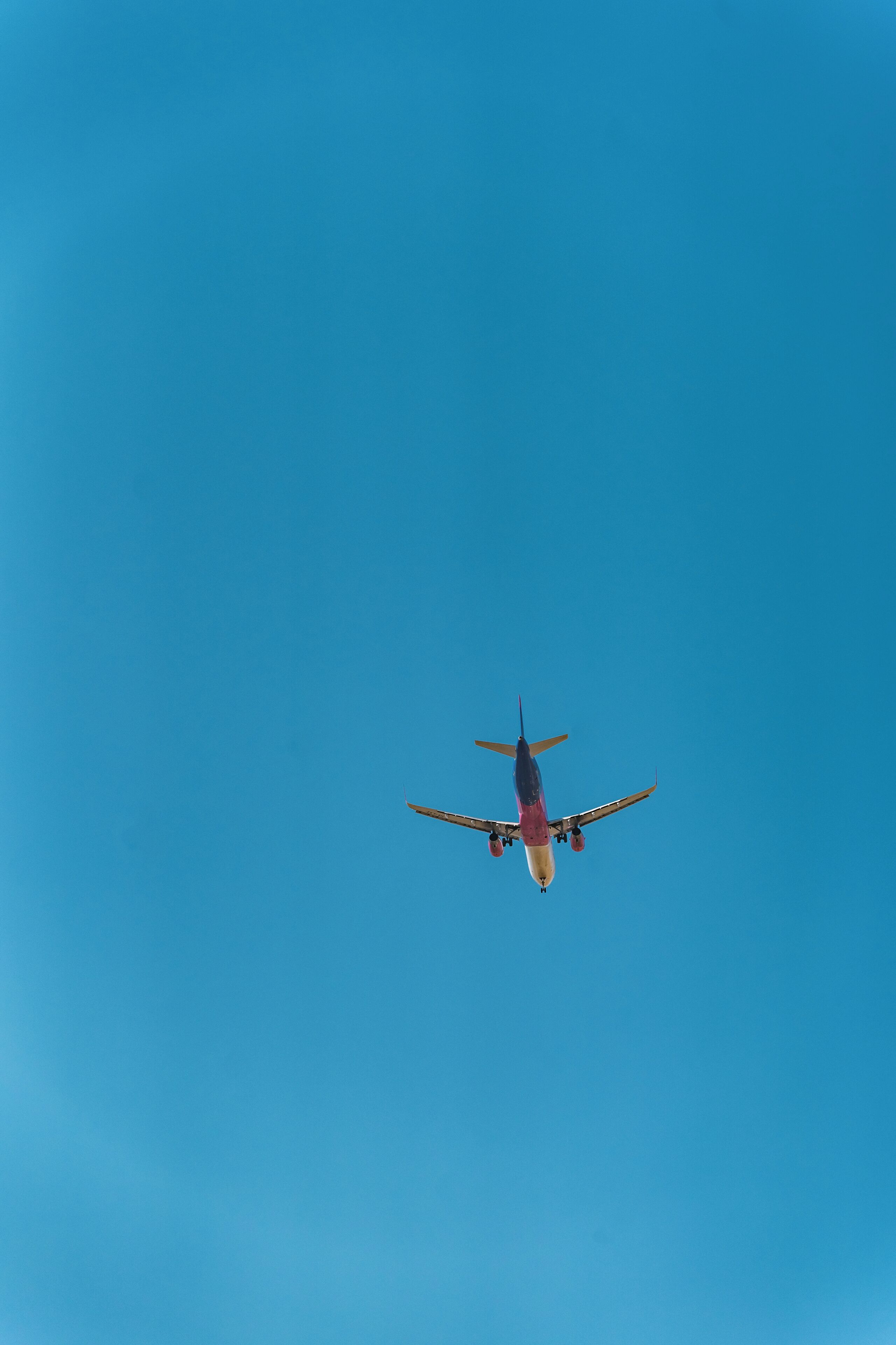 An airplane flying against a clear blue sky.