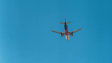 An airplane flying against a clear blue sky.