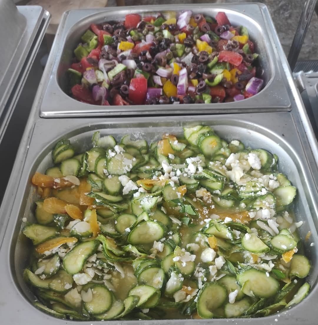 Dos bandejas de ensalada con pepinos, tomates y otras verduras.
