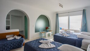 A hotel room with two beds, a small table with chairs, a view of the sea, and a balcony with curtains. - New Paradise Beach Resort- Adults Only (Mykonos)