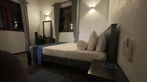 Une chambre à coucher comprenant un lit, une table de chevet, un miroir et un luminaire fixé au mur.