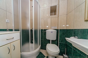 Ein Badezimmer mit Dusche, Toilette und Waschbecken.