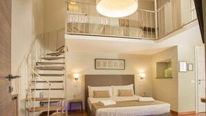 A bedroom with a large bed, a staircase, and a view of the upper floor. - Palazzo Depretis Naples (Naples)
