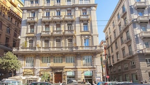 A multi-story building with balconies, a ground-level entrance, and signage for a supermarket and a restaurant. - Palazzo Depretis Naples (Naples)