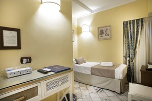 A hotel room with a bed, bedside table, lamp, and a framed certificate on the wall. - Alloggio dei Vassalli, In the Heart of the Historic Center (Naples)