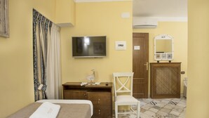 A hotel room with a bed, a TV, a dresser, a chair, and a mirror. - Alloggio dei Vassalli, In the Heart of the Historic Center (Naples)