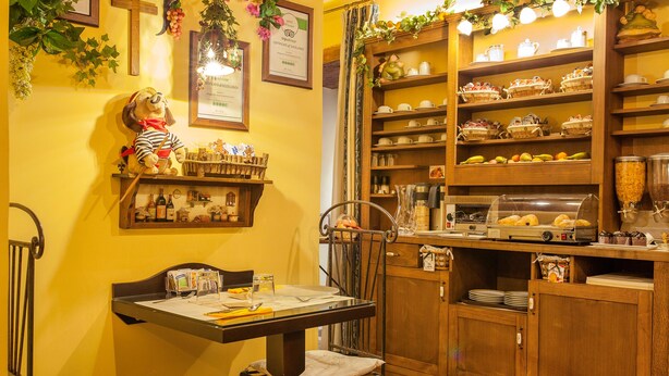 A cozy breakfast area with a table, chairs, and a variety of breakfast items on shelves. - Alloggio dei Vassalli, In the Heart of the Historic Center (Naples)