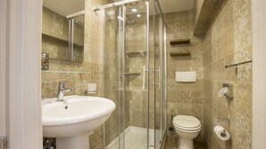A modern bathroom with a glass-enclosed shower, a white sink, and a toilet. - Palazzo Depretis Naples (Naples)