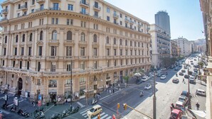 Un immeuble à plusieurs étages, de style architectural classique, doté de balcons et de fenêtres en arc de cercle.