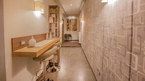 Un baño moderno con tocador de madera, un espejo y una estantería con libros y un jarrón.
