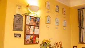 A wall with clocks, a bookshelf, and a sign indicating a welfare center. - Double Triple Room in Naples City Center (Naples)