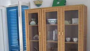 A wooden cabinet with glass doors, a blue door, and a patterned floor. - House "sole" - Unique Panorama (Lipari)